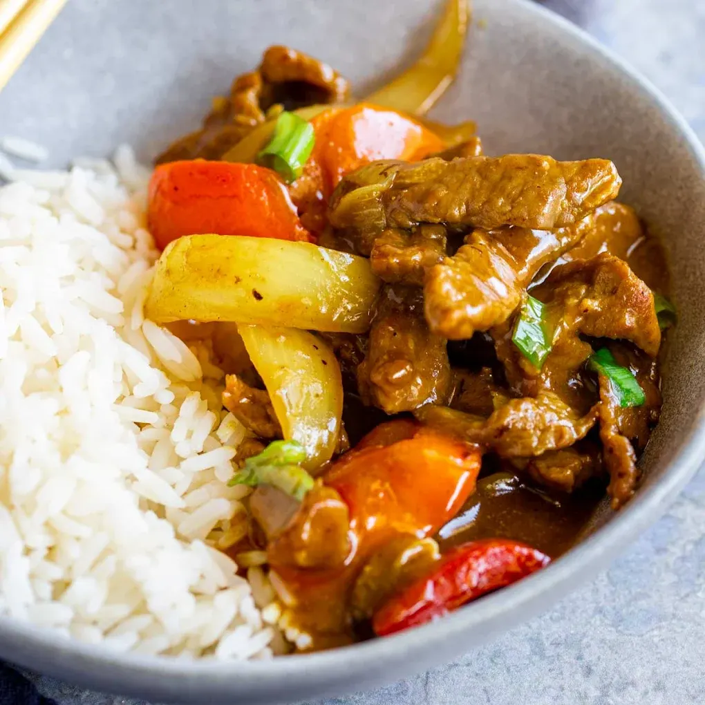 Tender beef with onions and tomato over steamed rice — Chinese-American comfort food